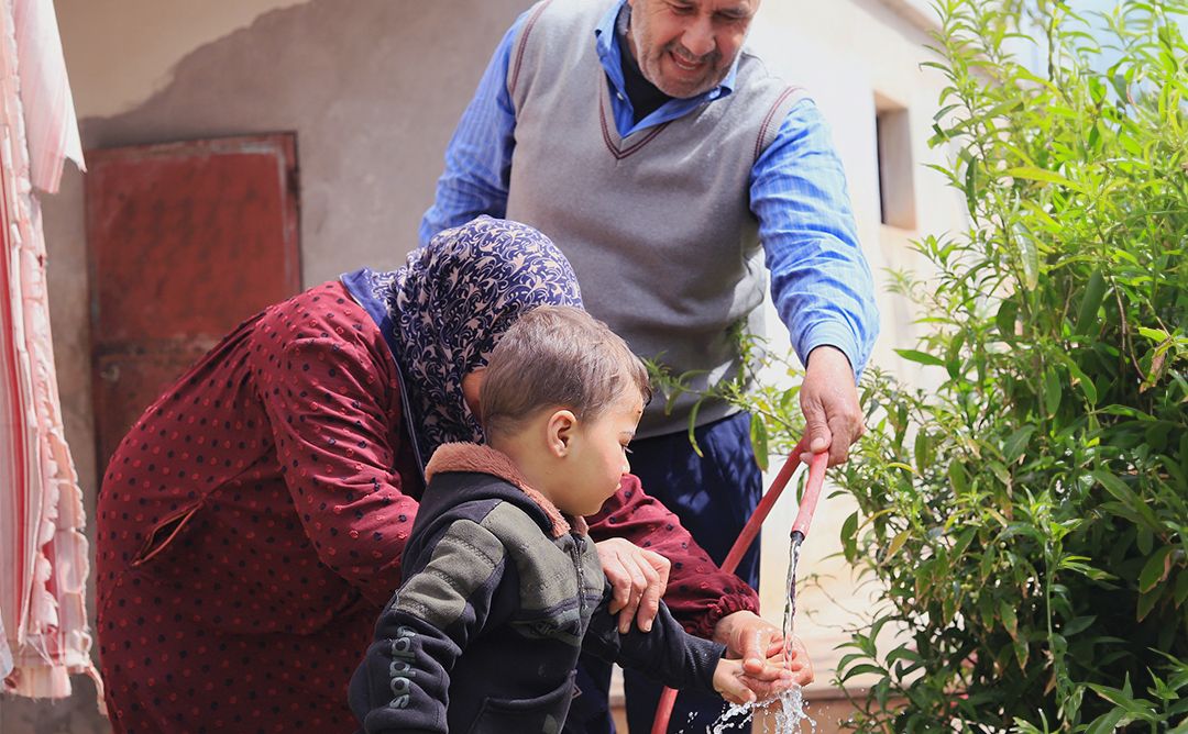 Eine syrische Familie wäscht sich in Idleb im Nordwesten Syriens die Hände mit kürzlich wiederhergestelltem Leitungswasser.