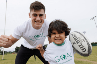 Dan Sheehan, Irish International Rugby Player with four year old Aria Shahab, at UCD Rugby Pitch -GOAL Ambassador.